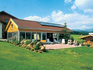 a house with a porch with a patio and aconservancy at Hanneshof in Riedlhütte
