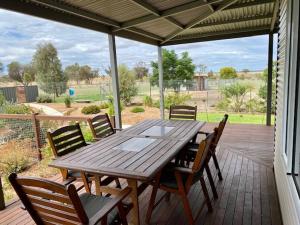 a wooden table and chairs on a patio at The Mains Guest House 2 Bedroom Farm Stay in Corrigin