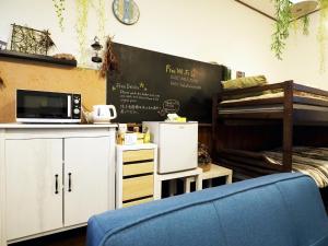 a classroom with a bed and a chair and a chalkboard at Mikan Hotel in Uwano