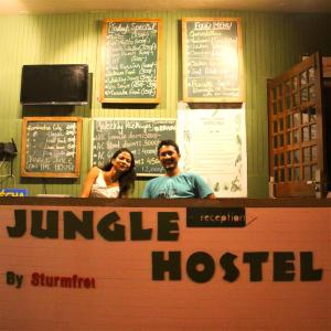 un hombre y una mujer parados detrás de un mostrador en un restaurante en Jungle by sturmfrei Vagator en Vagator