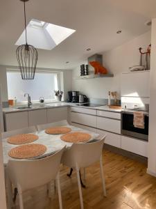 cocina con mesa, sillas y fregadero en Alapause, en Wimereux