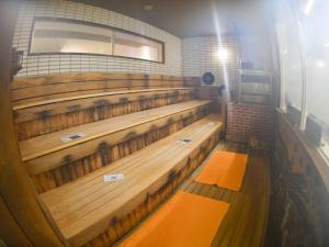 a row of wooden seats in a room at Takasago Onsen in Asahikawa