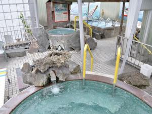 a swimming pool with two jacuzzi tubs and a spa at Takasago Onsen in Asahikawa