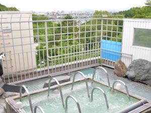 a hot tub on the roof of a building at Takasago Onsen in Asahikawa