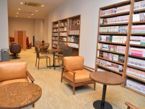 a library with chairs and tables and books at Takasago Onsen in Asahikawa