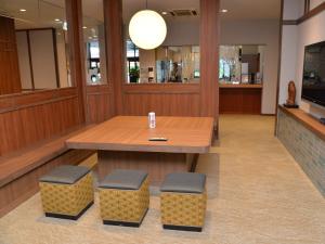 a conference room with a table and two stools at Takasago Onsen in Asahikawa