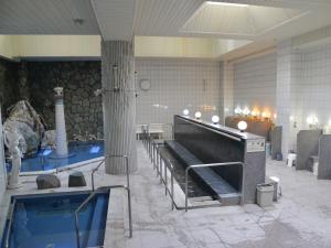 a large room with a swimming pool in a building at Takasago Onsen in Asahikawa