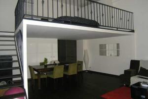 Sala de estar con mesa de comedor y loft en Judit Apartman, en Budapest