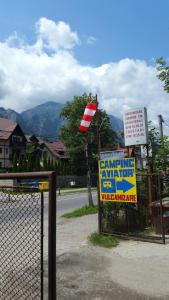 a sign next to a fence with a flag and a sign at camping aviator, numai TEREN, campare pentru rulote autorulote PERSONALE, Campingul nu are rulote !!! Busteni in Buşteni