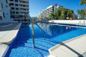 basen z niebieską wodą w budynku w obiekcie Family Duplex Altamira Playa Las Americas Tenerife South w Aronie