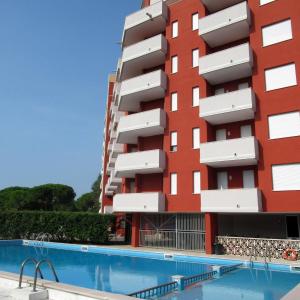 um hotel com piscina em frente a um edifício em Modern flat for 6 with shared pool em Porto Santa Margherita di Caorle