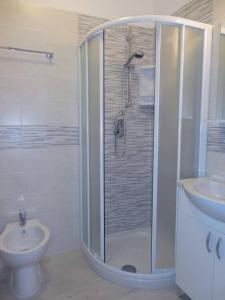 uma casa de banho com um chuveiro, um WC e um lavatório. em Modern flat for 6 with shared pool em Porto Santa Margherita di Caorle