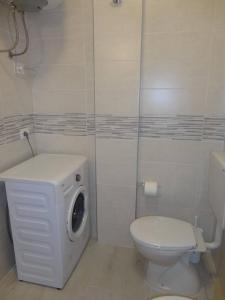 uma casa de banho com um WC e uma máquina de lavar roupa em Modern flat for 6 with shared pool em Porto Santa Margherita di Caorle