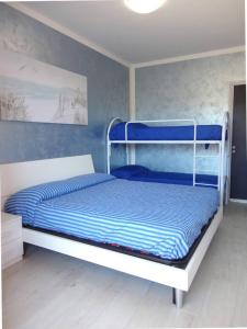 um quarto com um beliche com paredes azuis em Modern flat for 6 with shared pool em Porto Santa Margherita di Caorle