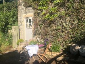 a table and chairs in front of a building at Hob Lane Farm Cottage in Oughtibridge