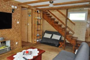 a living room with a staircase and a couch at Leśniczówka Święty Spokój Bieszczady in Ropienka