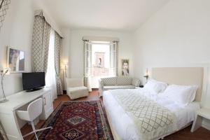 a hotel room with a white bed and white walls at Hotel San Miniato in San Miniato