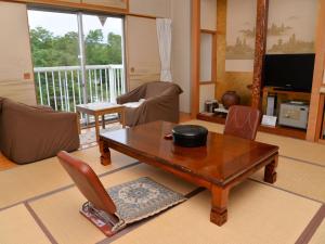 a living room with a wooden table and chairs at Takasago Onsen in Asahikawa