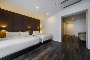 ソウルにあるチョンノ アマーレ ホテルのベッド2台とソファが備わるホテルルームです。