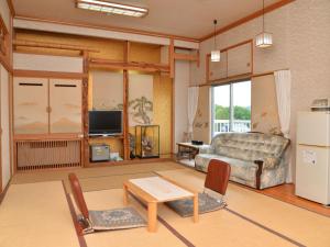 a living room with a couch and a table at Takasago Onsen in Asahikawa