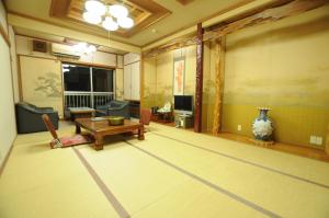 a living room with a table and a couch and a table at Takasago Onsen in Asahikawa
