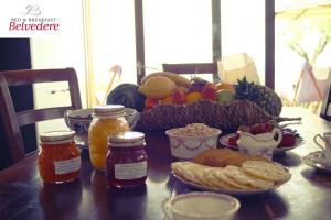 uma mesa com uma taça de fruta e um cesto de comida em B&B Belvedere em Castiglione delle Stiviere