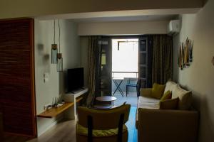 een woonkamer met een bank en een televisie bij Ikaros Art Hotel in Agios Nikolaos