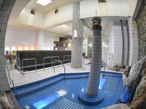 a large swimming pool in a large building with a pool at Takasago Onsen in Asahikawa