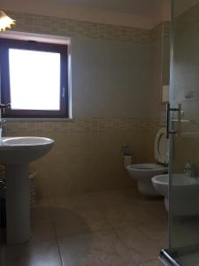 łazienka z 2 toaletami, umywalką i oknem w obiekcie La Collina dei Goti Agriturismo ,Azienda Agricola w mieście Cerreta
