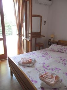 a bedroom with a bed with purple flowers on it at Mikulin Apartments in Lumbarda