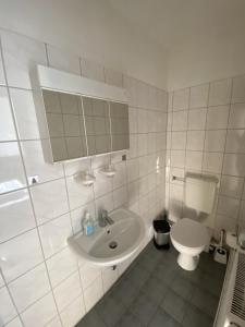 ein weißes Bad mit einem WC und einem Waschbecken in der Unterkunft Margarethenhof in Sankt Margarethen