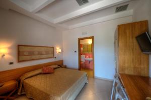 a bedroom with a bed and a flat screen tv at Hotel Zeus in Pompei