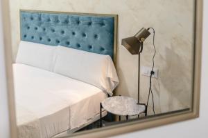 a mirror reflecting a bedroom with a bed and a table at Villamarta Boutique Rooms in Jerez de la Frontera