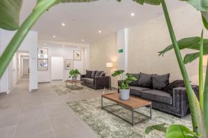 una sala de estar con sofás y plantas. en Villamarta Boutique Rooms en Jerez de la Frontera