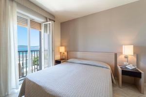 a hotel room with a large bed and a large window at Hotel San Giuan in Alghero