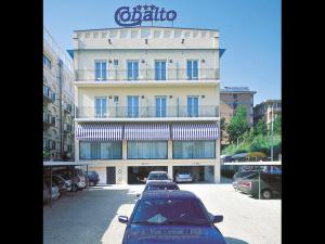 um grande edifício com carros estacionados em frente em Hotel Cobalto em Rimini