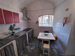 a small kitchen with a table and a sink at Casa do Pateo in Casa Branca