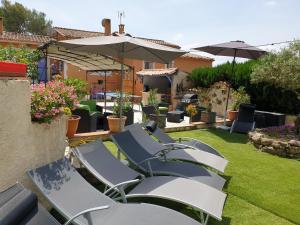 een groep ligstoelen in een tuin bij La Villa Poupée in Grambois