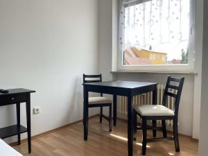 uma mesa preta e cadeiras num quarto com uma janela em SAD161 - Gut geschnittene Monteurwohnung mit Balkon em Schwandorf