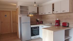 Una cocina con gabinetes blancos y un refrigerador blanco. en Appartement 8 personnes à 3 minutes des pistes, en Le Dévoluy 16 fotos más