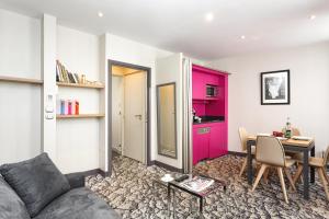 a living room with a couch and a table at Serotel Suites Opera in Paris