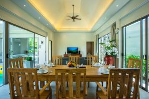 ein Esszimmer mit einem Holztisch und Stühlen in der Unterkunft Yipmunta Pool Villa - SHA Plus Certified in Strand Bang Tao