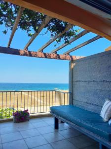 un banco sentado en un porche con vistas a la playa en Philos House, en AgiaKampos