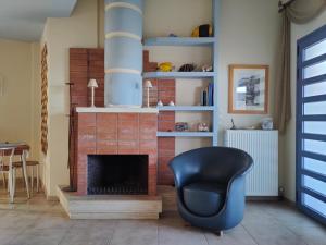 a living room with a chair and a fireplace at Philos House in Agiokampos