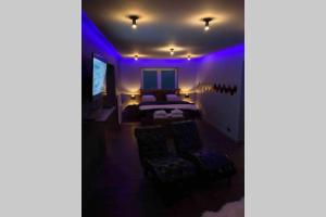 um quarto roxo com uma cama e duas cadeiras em El nido Malaika-Villa privative em Monts
