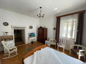 een slaapkamer met een bed en stoelen en een televisie bij Casa Morar in Sighişoara