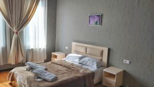 1 dormitorio con 1 cama con 2 almohadas en Gamarjoba Hotel en Tiflis