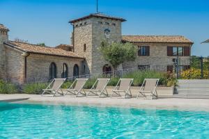een groep ligstoelen naast een zwembad bij Villa Flavia 20 in Filottrano
