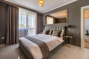 a bedroom with a large bed and a mirror at Urbio Private Suites in Cluj-Napoca