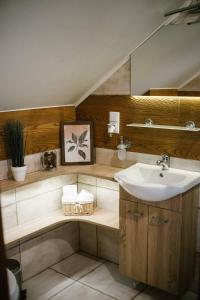 a bathroom with a sink and a mirror and a sink at Willa Zacisze - Apartament dwupoziomowy in Kalwaria Zebrzydowska